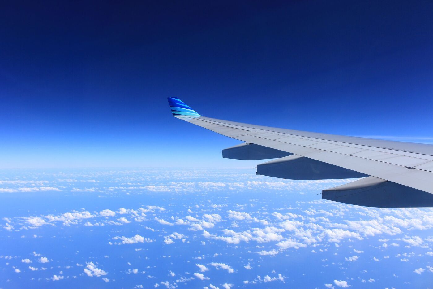 Aircraft wing above cloud cover. Reference photograph, not a company aircraft.